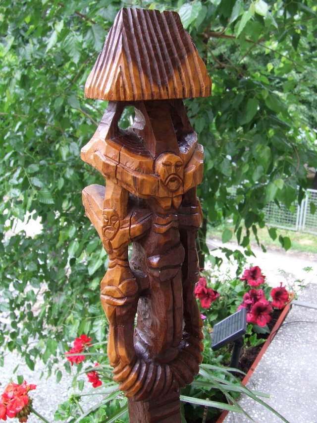 Statuie infatisand o baba rugandu-se la o troita Statuie infatisand o baba rugandu-se la o troita